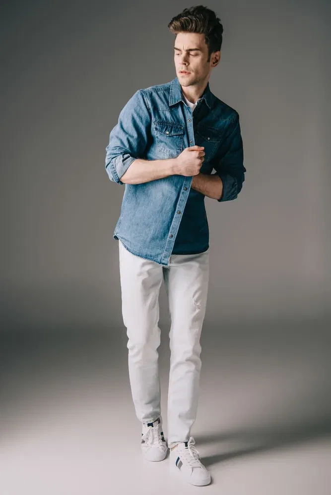 man in denim shirt and white jeans