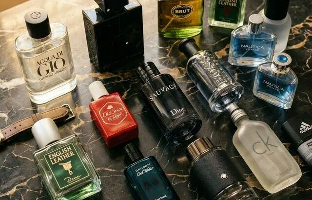 Collection of mens cologne bottles under 50 dollars on dark marble surface