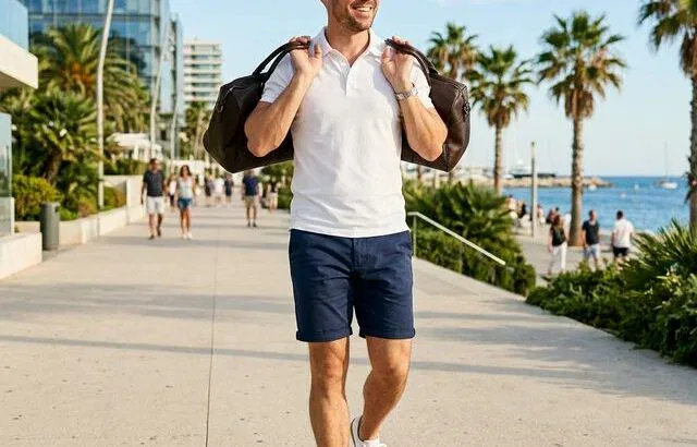 Man wearing navy shorts and white polo in summer outfit