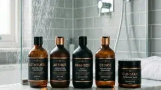 Premium men's shampoo bottles on marble shower ledge