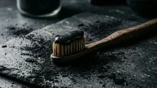 Black charcoal toothpaste on bamboo toothbrush