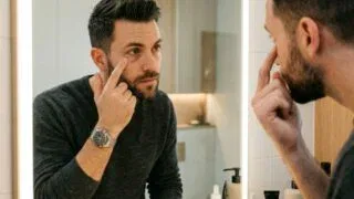 Man Examining Dark Circles Under Eyes