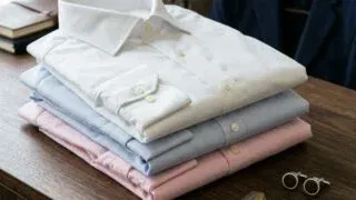 Stack of men's dress shirts in white, blue and pink