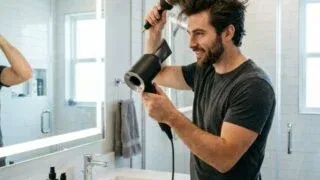 Man blow-drying hair with round brush for volume