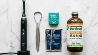 Men's oral care essentials flatlay: toothbrush, floss, tongue scraper, mouthwash
