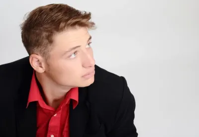 black suit with unbuttoned red shirt